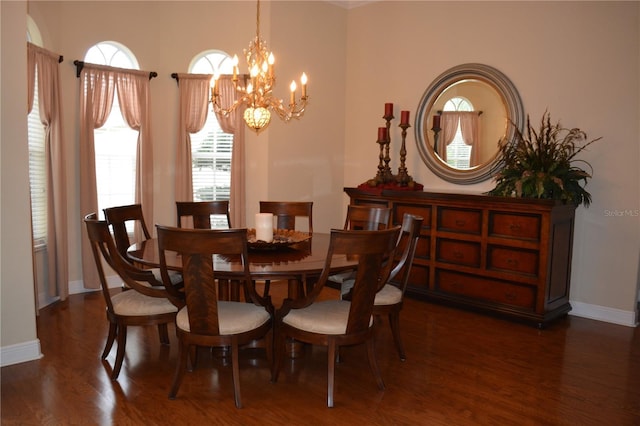 dining area featuring wood finished floors, baseboards, and a chandelier