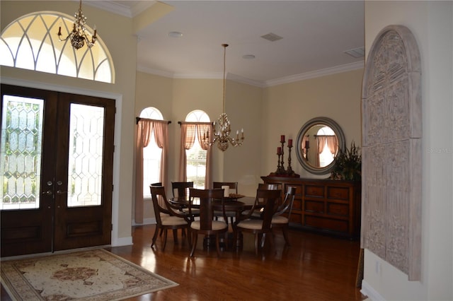 entrance foyer with visible vents, crown molding, a chandelier, french doors, and wood finished floors