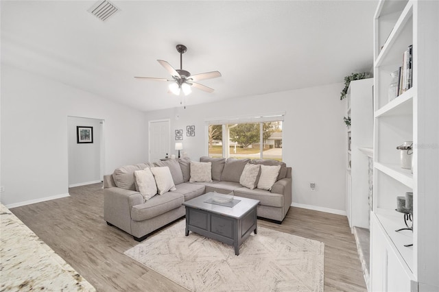 living room featuring light wood-style flooring, visible vents, ceiling fan, and baseboards