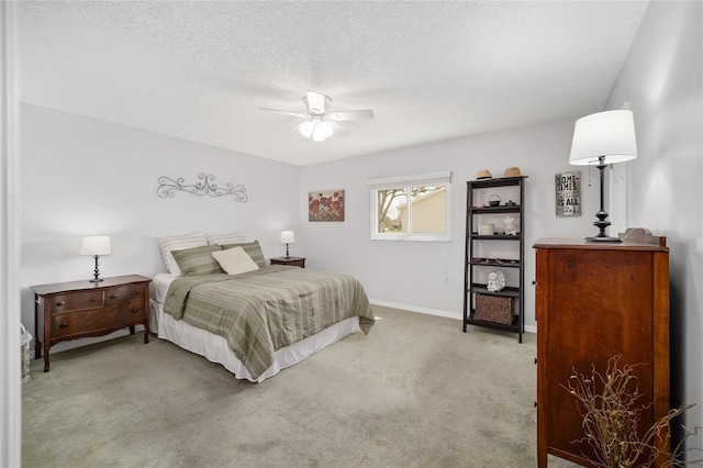 carpeted bedroom featuring ceiling fan, a textured ceiling, and baseboards