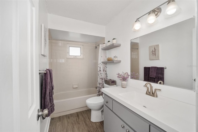 full bathroom with shower / tub combo, toilet, wood finished floors, a textured ceiling, and vanity