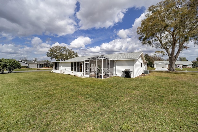 back of property featuring a sunroom, a yard, and central air condition unit