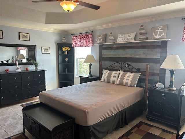 bedroom featuring ornamental molding, a tray ceiling, ceiling fan, and tile patterned floors