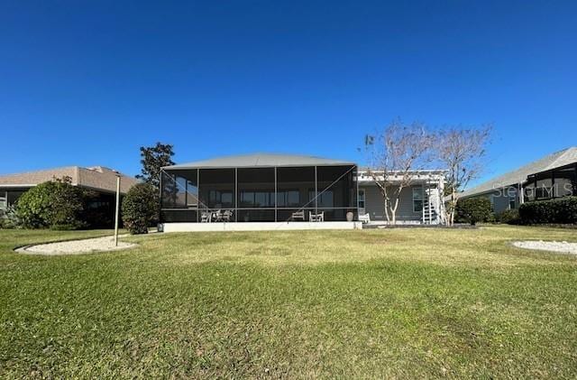 rear view of house with a sunroom and a lawn