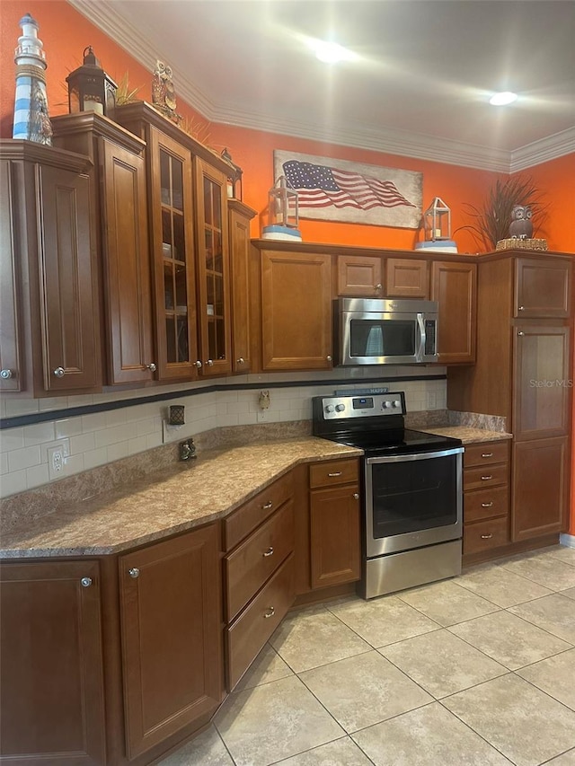 kitchen with stainless steel appliances, glass insert cabinets, ornamental molding, and backsplash