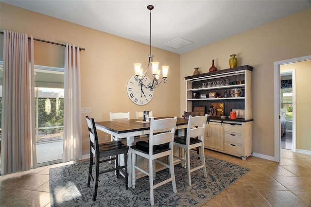 dining space featuring light tile patterned floors, baseboards, and a chandelier