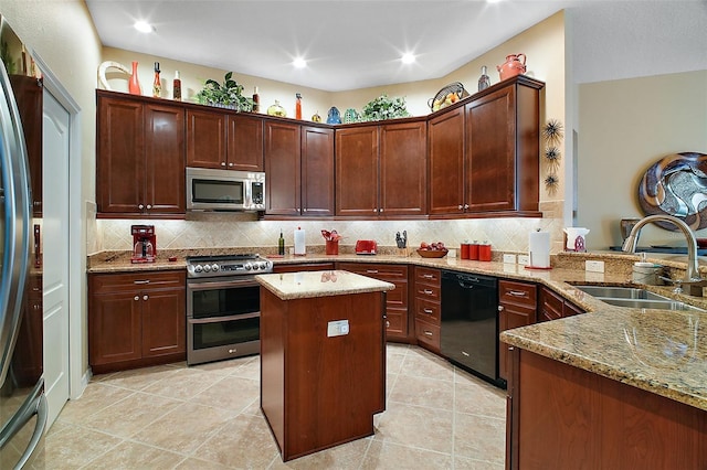 kitchen with stainless steel appliances, tasteful backsplash, a sink, light stone countertops, and a peninsula