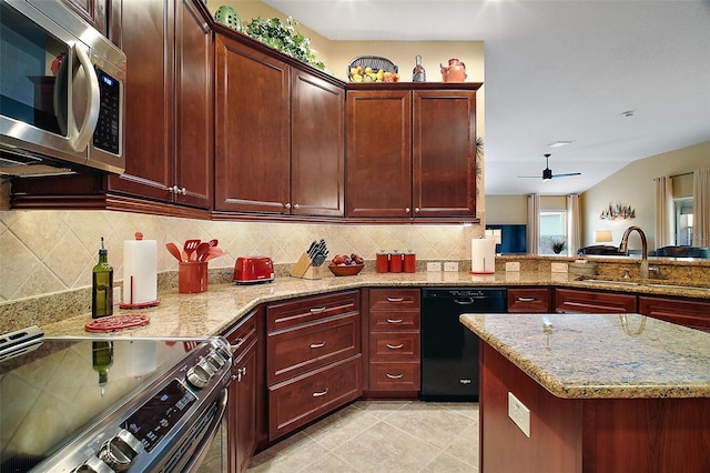 kitchen featuring light tile patterned floors, stainless steel appliances, a sink, decorative backsplash, and reddish brown cabinets