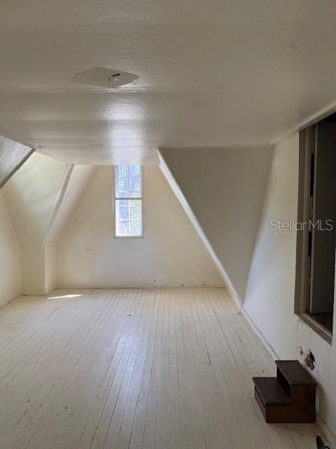 bonus room featuring vaulted ceiling and hardwood / wood-style floors