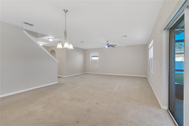 empty room with light colored carpet, visible vents, ceiling fan, and baseboards