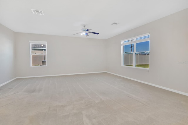 unfurnished room with light colored carpet, visible vents, and baseboards