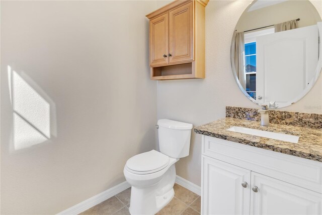 half bath featuring toilet, tile patterned flooring, baseboards, and vanity