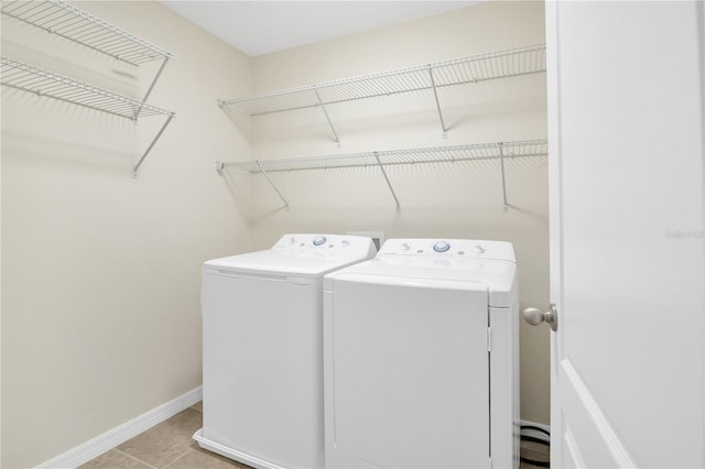 laundry area with laundry area, tile patterned flooring, baseboards, and washer and dryer