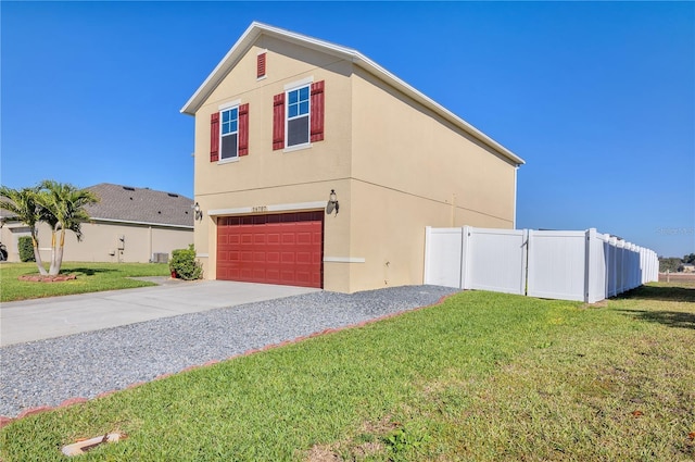 view of side of home with driveway, fence, a lawn, and stucco siding