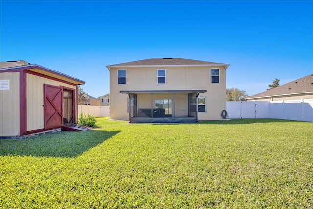 back of property featuring an outbuilding, a yard, and a fenced backyard