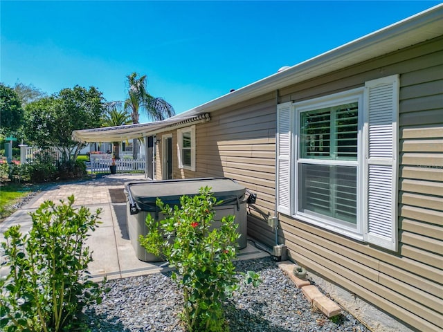 exterior space with a patio area, fence, and a hot tub