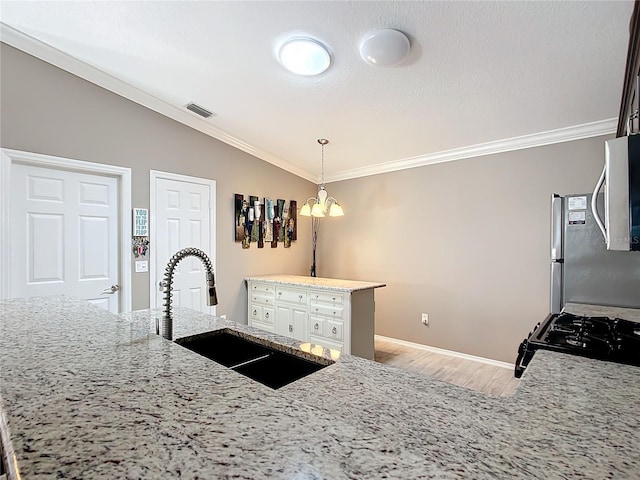 kitchen featuring crown molding, light wood-type flooring, visible vents, and a sink