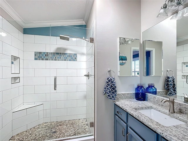 bathroom with a shower stall, vanity, and crown molding