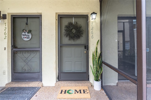 property entrance with stucco siding