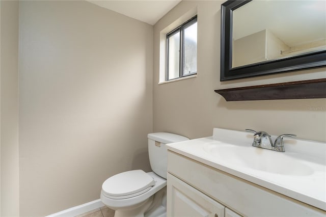 bathroom with baseboards, vanity, toilet, and tile patterned floors