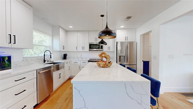 1930 Hilltop Dr, Mount Dora, FL 32757 - kitchen with visible vents, a center island, stainless steel appliances, light wood-style floors, and a sink