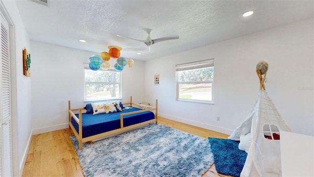 1930 Hilltop Dr, Mount Dora, FL 32757 - bedroom with a textured ceiling, multiple windows, baseboards, and wood finished floors