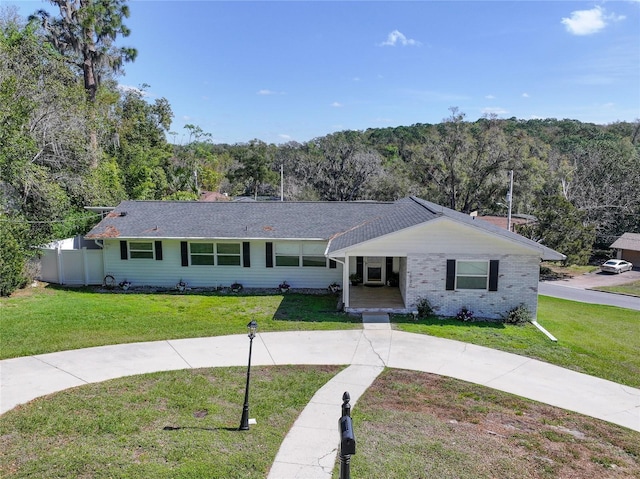 1930 Hilltop Dr, Mount Dora, FL 32757 - ranch-style home with a front yard, fence, and a view of trees