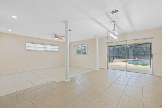 spare room featuring ornate columns, a ceiling fan, light tile patterned flooring, a textured ceiling, and baseboards