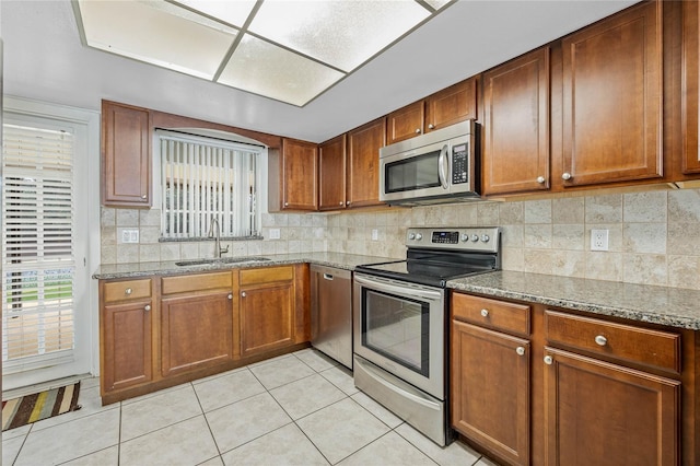 kitchen featuring stainless steel appliances, a sink, and brown cabinets