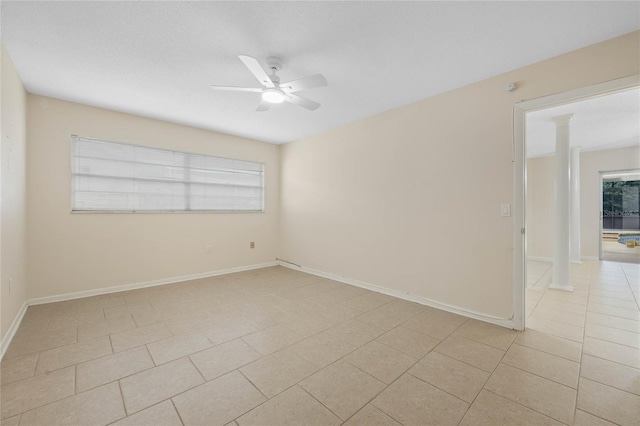 unfurnished room with light tile patterned floors, decorative columns, baseboards, and a ceiling fan