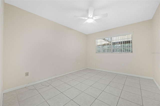 unfurnished room with ceiling fan, light tile patterned flooring, and baseboards