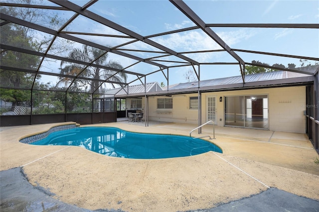 outdoor pool featuring glass enclosure and a patio