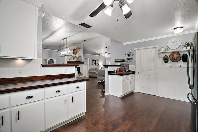 kitchen with visible vents, dark wood-style floors, ceiling fan, freestanding refrigerator, and a peninsula