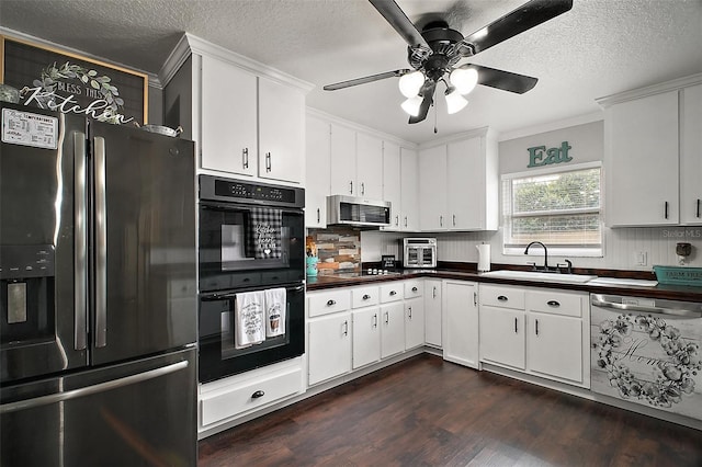 kitchen featuring dark wood-style floors, stainless steel appliances, dark countertops, tasteful backsplash, and a sink