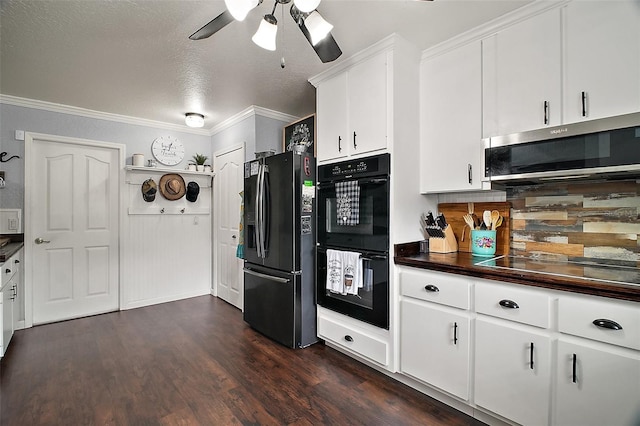 kitchen with dark wood-style flooring, dark countertops, ornamental molding, white cabinetry, and black appliances