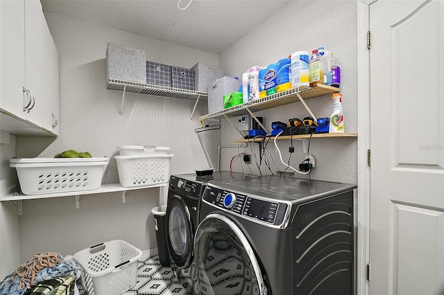 laundry area with independent washer and dryer and cabinet space