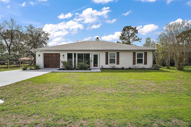 ranch-style home featuring an attached garage, concrete driveway, and a front yard