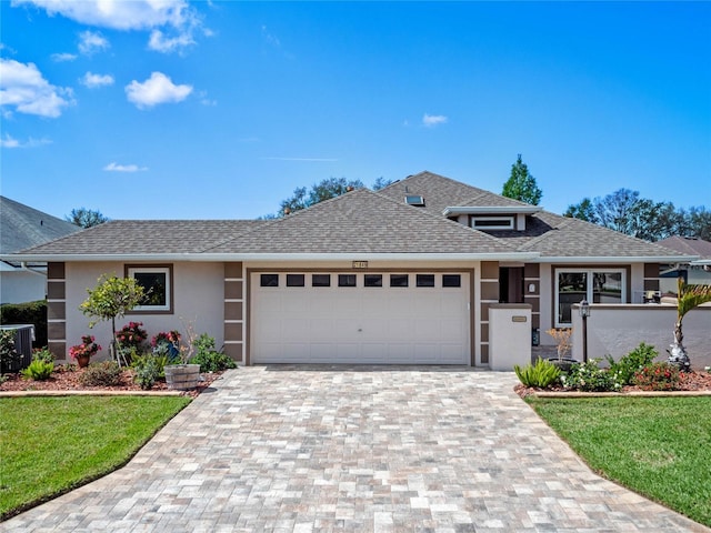 view of front facade with an attached garage, a shingled roof, decorative driveway, and stucco siding