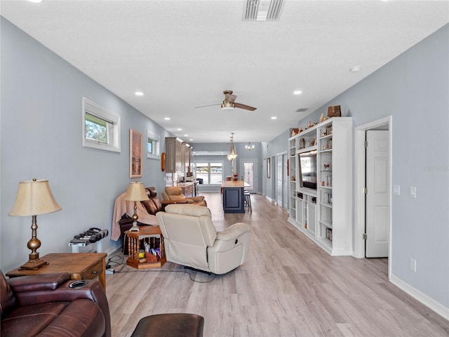 living room with visible vents, baseboards, a ceiling fan, light wood-style flooring, and recessed lighting