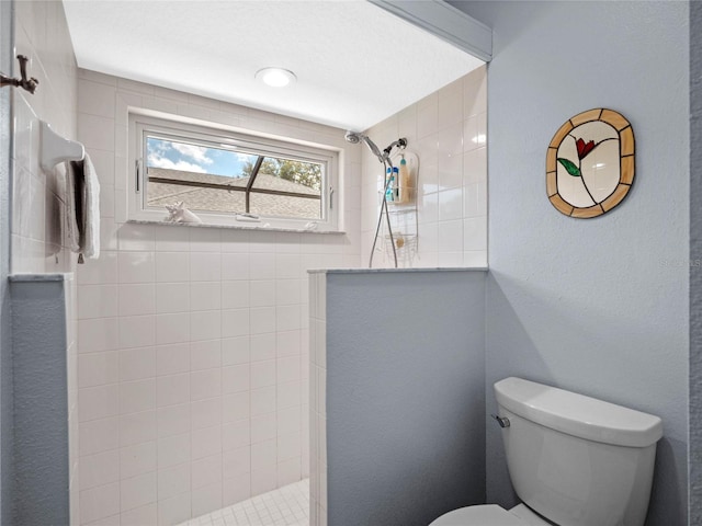 bathroom with a walk in shower, a textured wall, and toilet