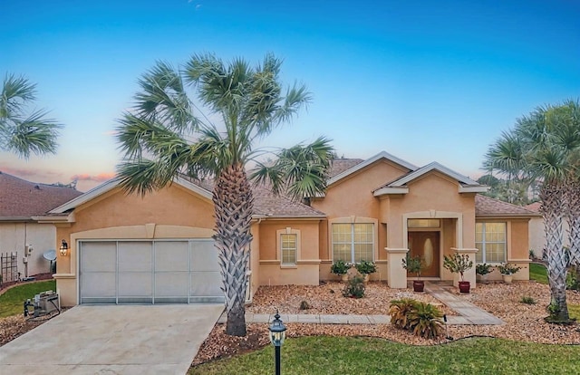 view of front of home with a garage, driveway, and stucco siding