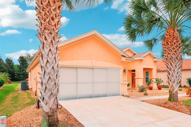 view of front of house with central air condition unit, stucco siding, concrete driveway, a garage, and a front lawn