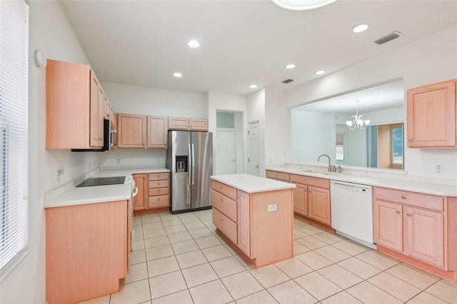 kitchen with a sink, visible vents, appliances with stainless steel finishes, a center island, and light brown cabinetry