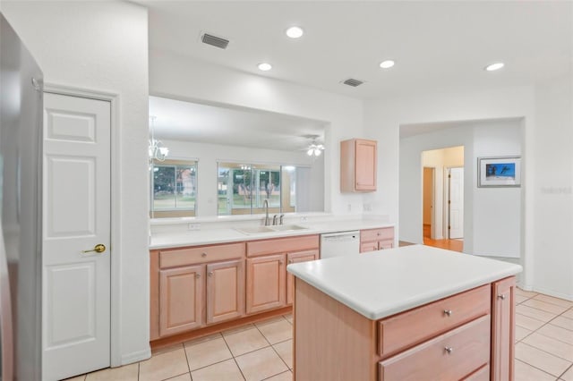 kitchen featuring visible vents, dishwasher, light brown cabinets, a sink, and recessed lighting