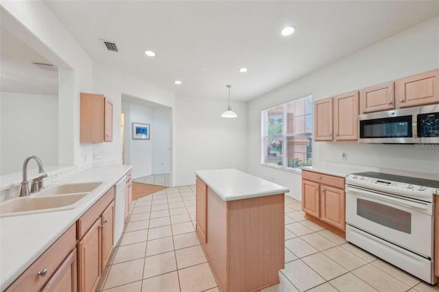 kitchen featuring light countertops, light brown cabinets, a kitchen island, a sink, and white appliances