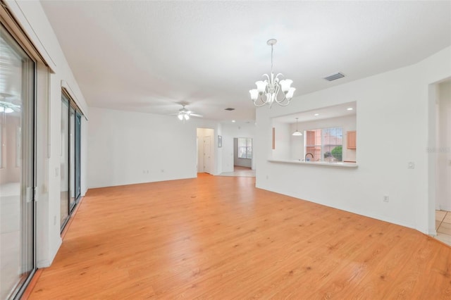 unfurnished living room with light wood-style floors, recessed lighting, visible vents, and ceiling fan with notable chandelier