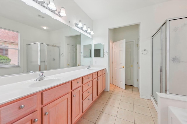 full bath featuring double vanity, a stall shower, a sink, and tile patterned floors