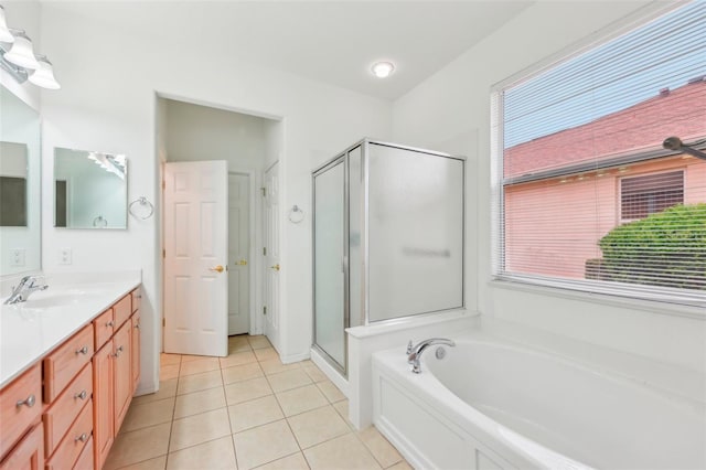 full bath featuring a stall shower, a garden tub, vanity, and tile patterned floors