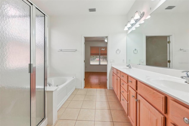 full bathroom with double vanity, visible vents, a sink, a shower stall, and tile patterned flooring