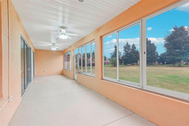 unfurnished sunroom with ceiling fan